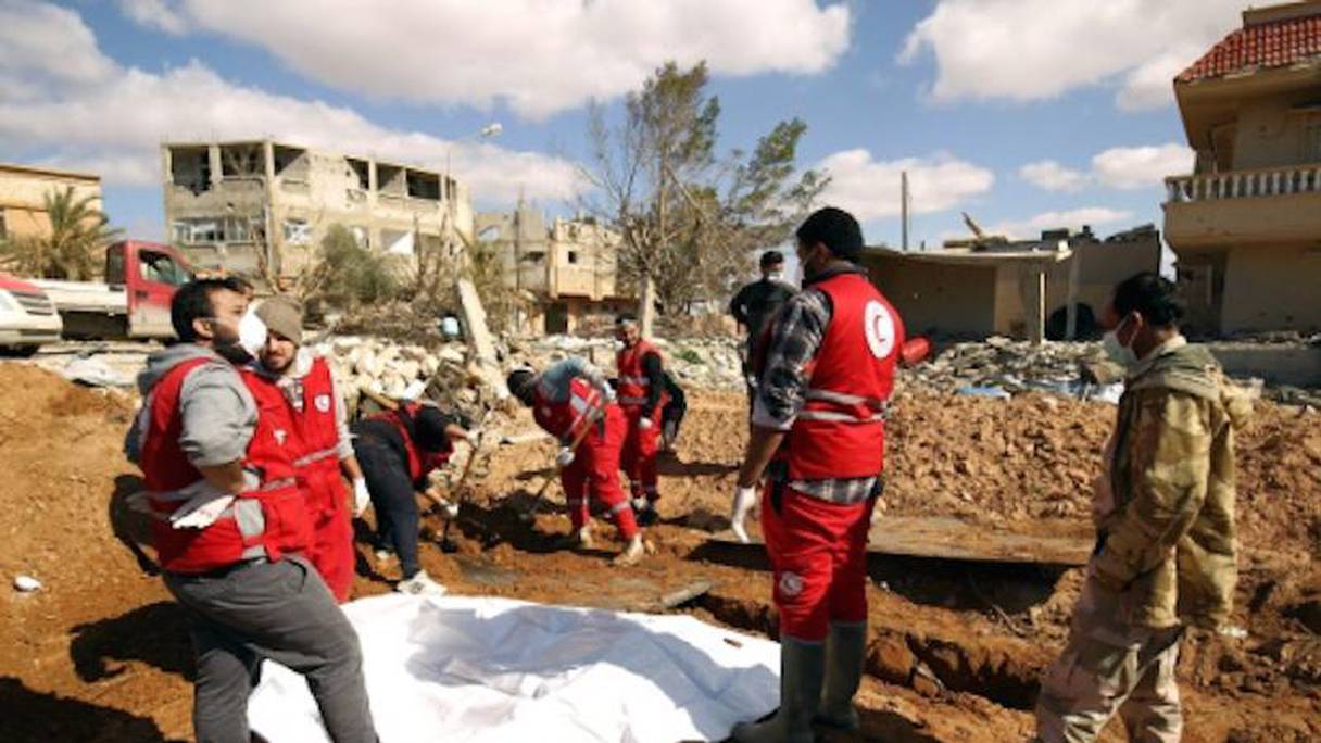 Des membres du Croissant-Rouge libyen à la recherche de cadavres après la découverte d'un charnier le 23 février 2017 dans la région de Benghazi (est) 
