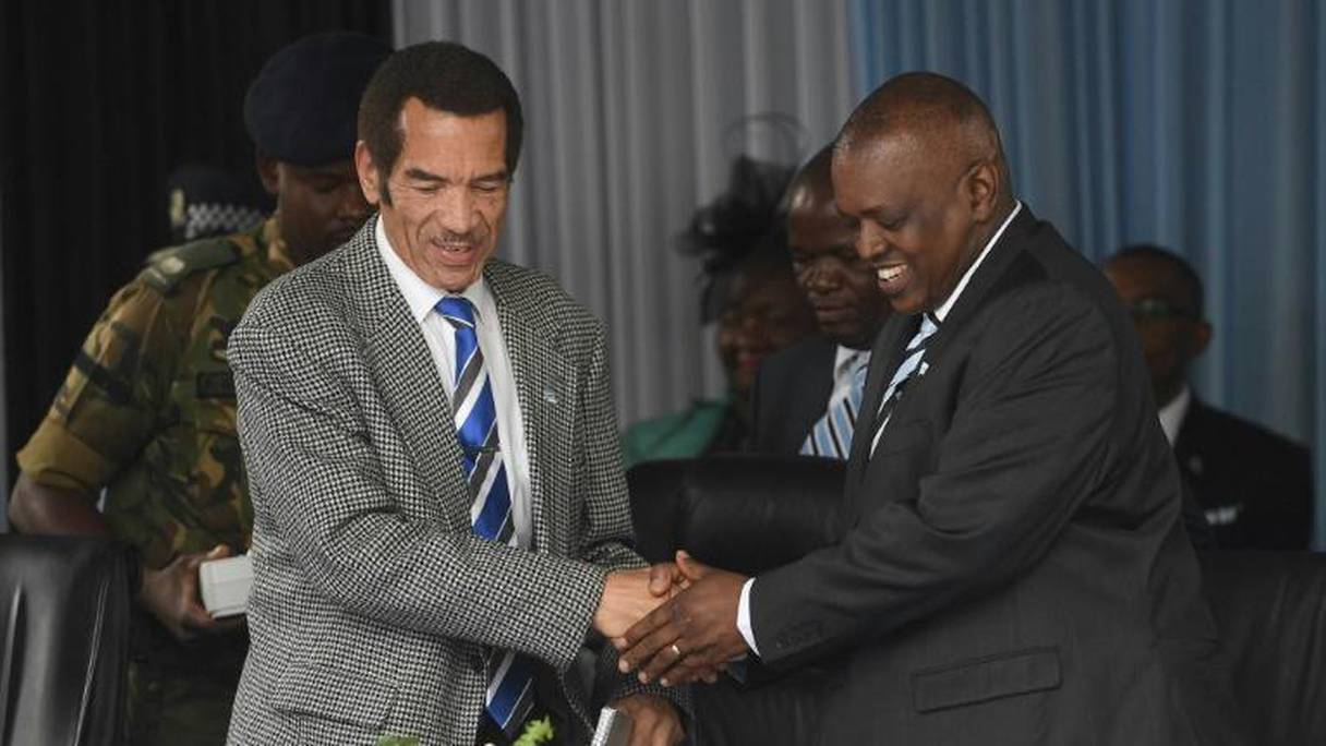 Le président du Botswana Ian Khama (à gauche) échange une poignée de main avec son successeur l'actuel vice-président Mokgweetsi Masisi (à droite) à Serowe le 27 mars 2018
