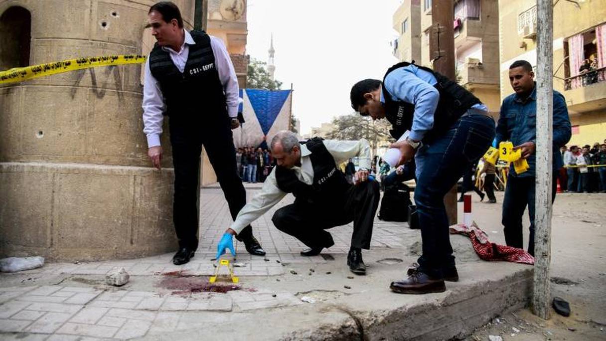 Des membres de la police judiciaire inspectent le site d'une attaque contre une église au sud du Caire, le 29 décembre 2017.