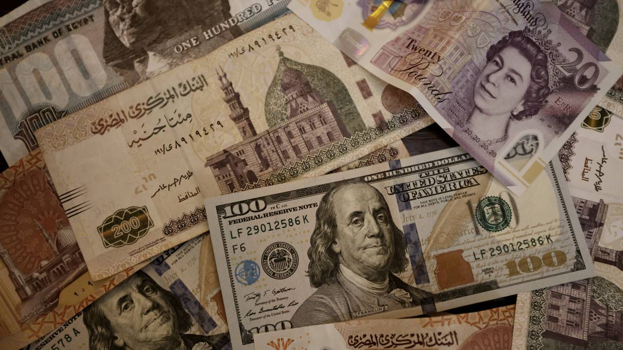 Une photo prise le 25 août 2022 montre des billets en livre égyptienne, en livre sterling et en dollars américains.