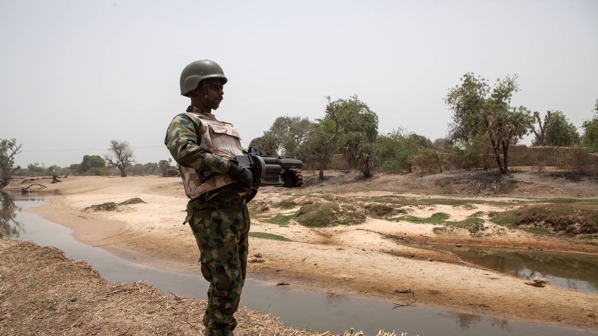 Un soldat nigérian, avec un lance-grenades, monte la garde près de la rivière Yobe, qui sépare le Nigeria du Niger, à la périphérie de la ville de Damasak dans le nord-est du Nigeria le 25 avril 2017 alors que des milliers de Nigérians, qui ont été libérés en 2016 par l'armée nigériane des insurgés de Boko Haram, rentrent chez eux à Damasak.