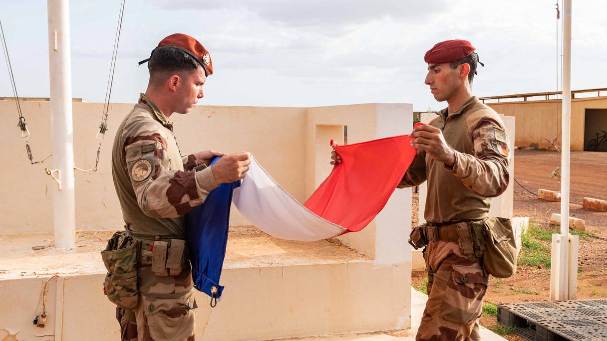 Photo prise le 11 août 2022 et publiée par l'État major des armées montre des soldats de la mission française au Sahel, Barkhane, pliant un drapeau français sur une installation militaire non divulguée.