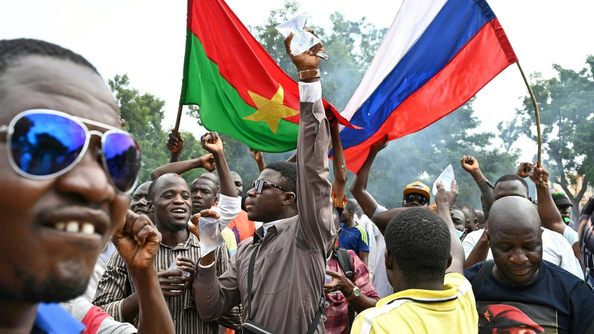 Les partisans du nouveau chef de la junte burkinabé Ibrahim Traoré tiennent les drapeaux nationaux du Burkina Faso et de la Russie lors d'une manifestation près du siège national de la radio et de la télévision (RTB) à Ouagadougou le 6 octobre 2022.