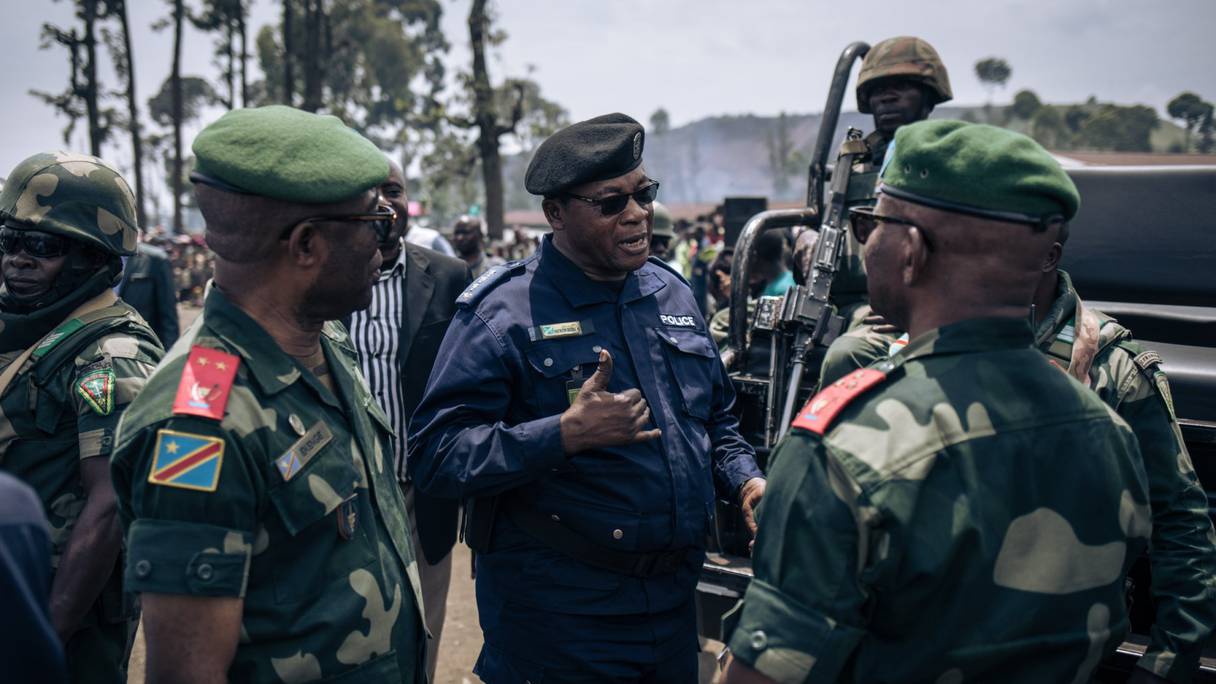 Des militaires et des policiers discutent à l'issue d'une réunion dans un camp informel de personnes déplacées qui ont fui l'avancée de la rébellion du M23 (Mouvement du 23 mars) à Kanyaruchinya, le district nord de Goma, le 2 novembre 2022.