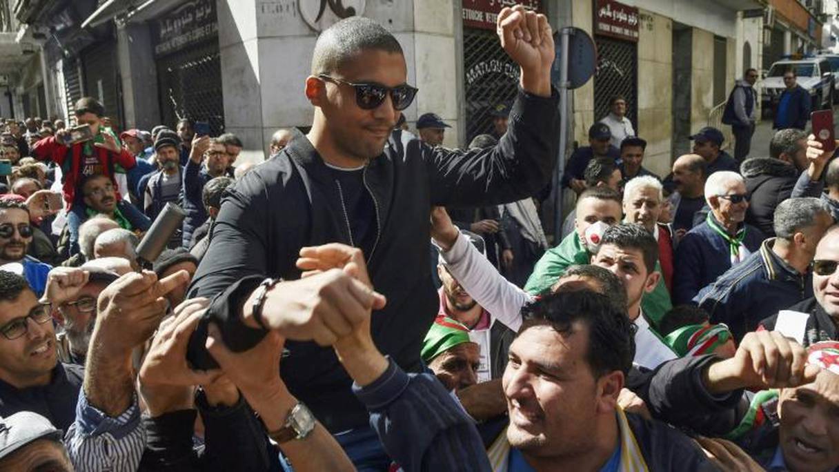 Des manifestants algériens portent le journaliste Khaled Drareni sur leurs épaules après avoir été brièvement détenu par les forces de sécurité dans la capitale algérienne le 7 mars 2020.