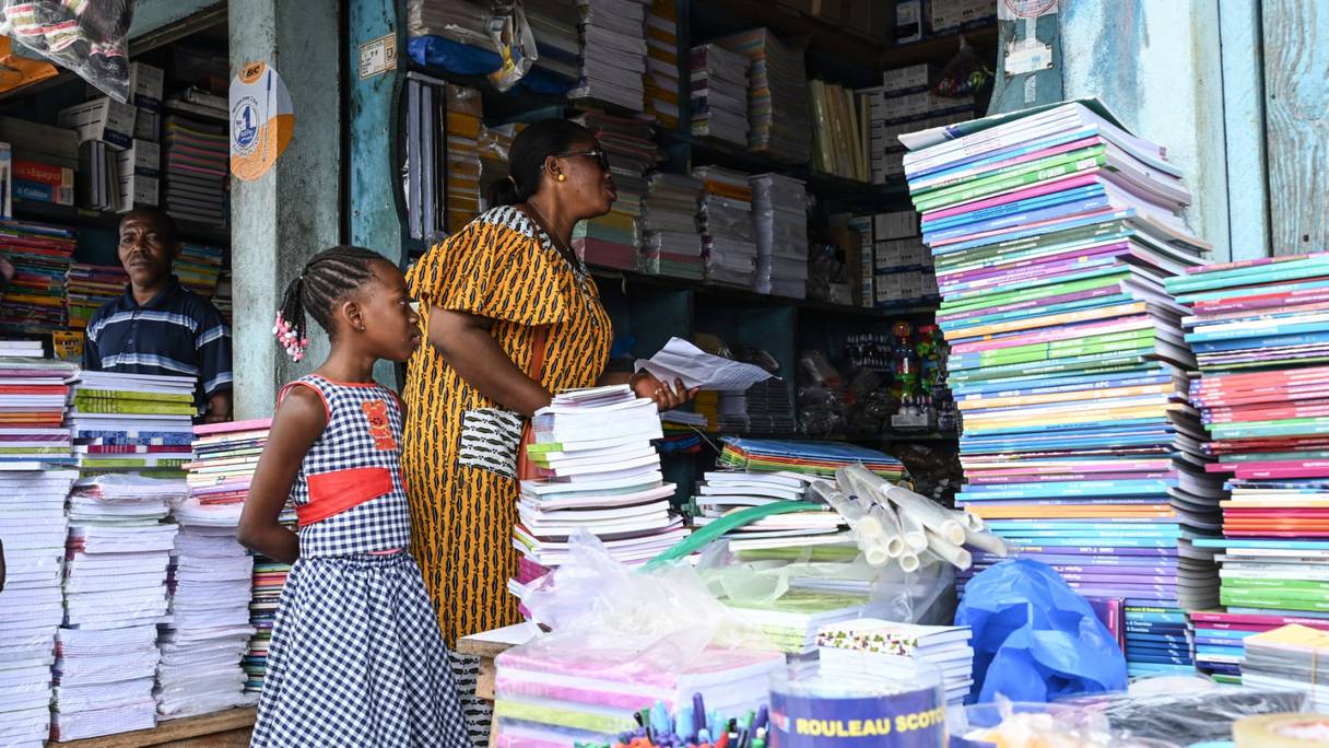 Une femme et sa fille à la recherche de fournitures scolaires dans la commune d'Adjamé, à Abidjan, le 16 septembre 2022.