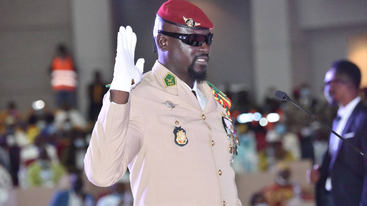 Le chef de la junte guinéenne, le colonel Mamady Doumbouya, lève la main lors de sa prestation de serment en tant que président de la transition du pays, le 1er octobre 2021 à Conakry.