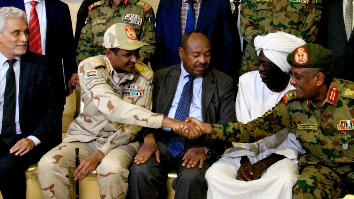  Le médiateur de l'Union africaine Mohamed El Hacen Lebatt, à gauche, aux côtés du général Mohamed Hamdan Dagalo qui serre la main au général Yaser al-Atta, à droite, le 5 juillet 2019. 