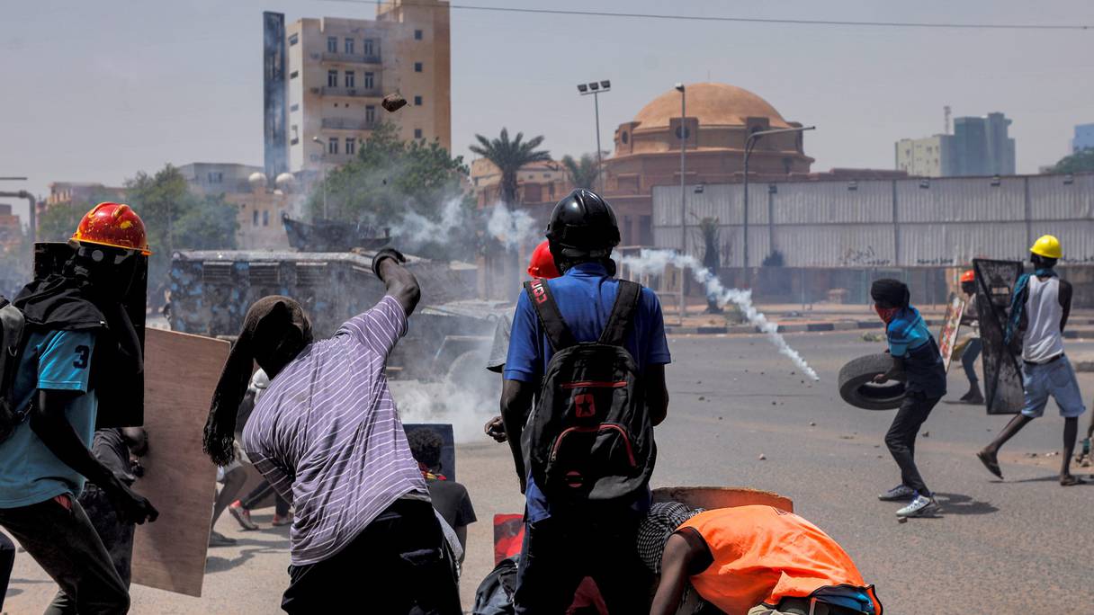 Des manifestants anti-coup d'État se cachent derrière des boucliers de fortune tandis que les forces de sécurité tirent des larmes lors d'affrontements au milieu de manifestations de masse contre le régime militaire dans le centre de la capitale soudanaise Khartoum le 30 juin 2022.