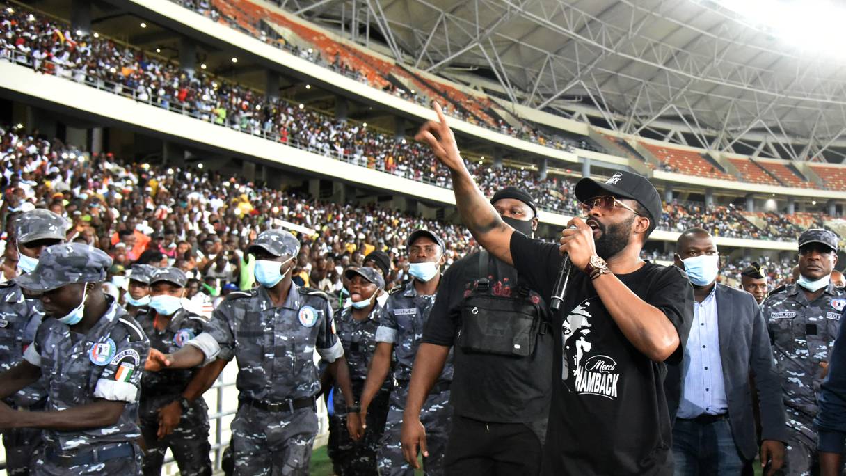 Le chanteur congolais Fally Ipupa (3e R), flanqué de policiers ivoiriens, se produit lors d'un concert en hommage à feu le Premier ministre ivoirien Hamed Bakayoko au stade olympique d'Ebimpe à Anyama, Abidjan, le 17 mars 2021. - Le Premier ministre ivoirien Hamed Bakayoko.
