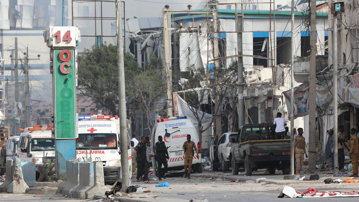 Le personnel de sécurité et les ambulances sont stationnés près des bâtiments détruits et endommagés après qu'un attentat à la voiture piégée a visé le ministère de l'Éducation à Mogadiscio le 29 octobre 2022.