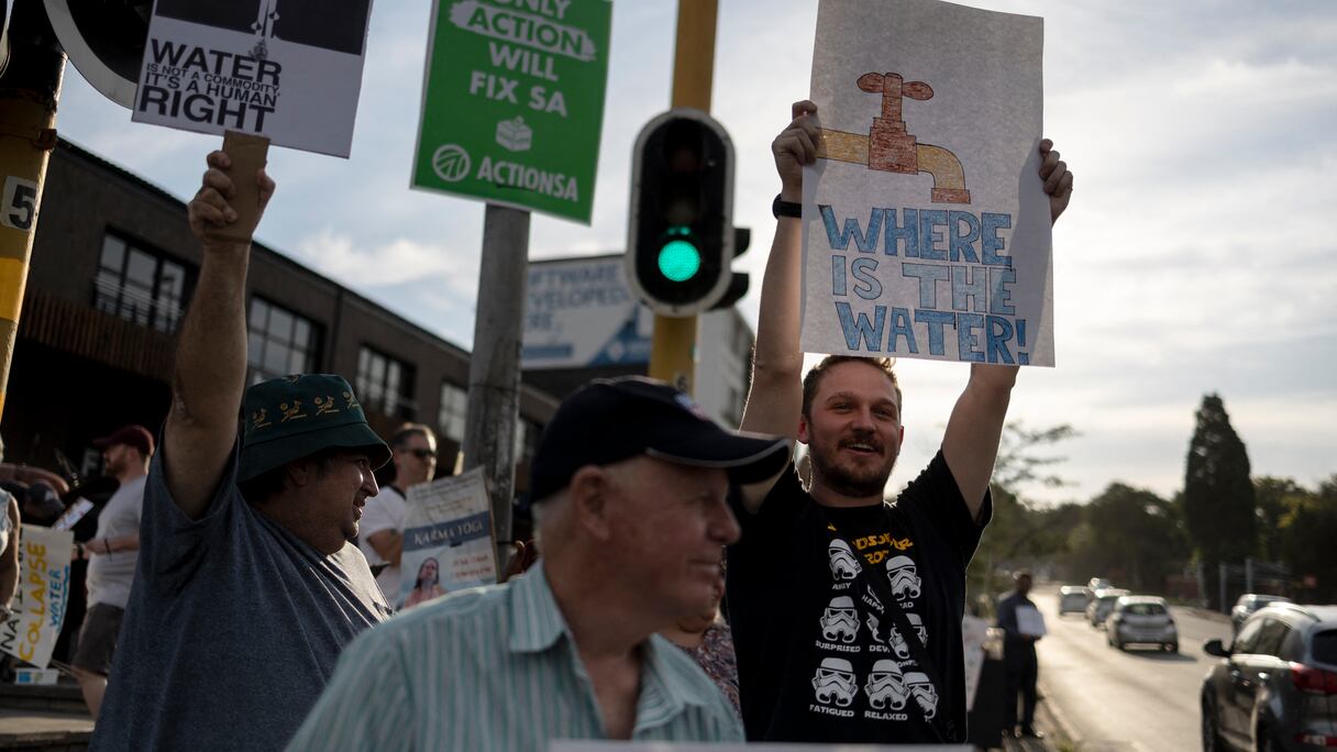 Des habitants brandissent des pancartes lors d'une manifestation contre l'absence d'accès à l'eau dans la région de Blairgowrie, à Johannesburg, le 12 mars 2024.