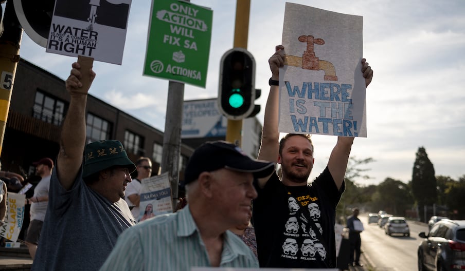 Des habitants brandissent des pancartes lors d'une manifestation contre l'absence d'accès à l'eau dans la région de Blairgowrie, à Johannesburg, le 12 mars 2024.