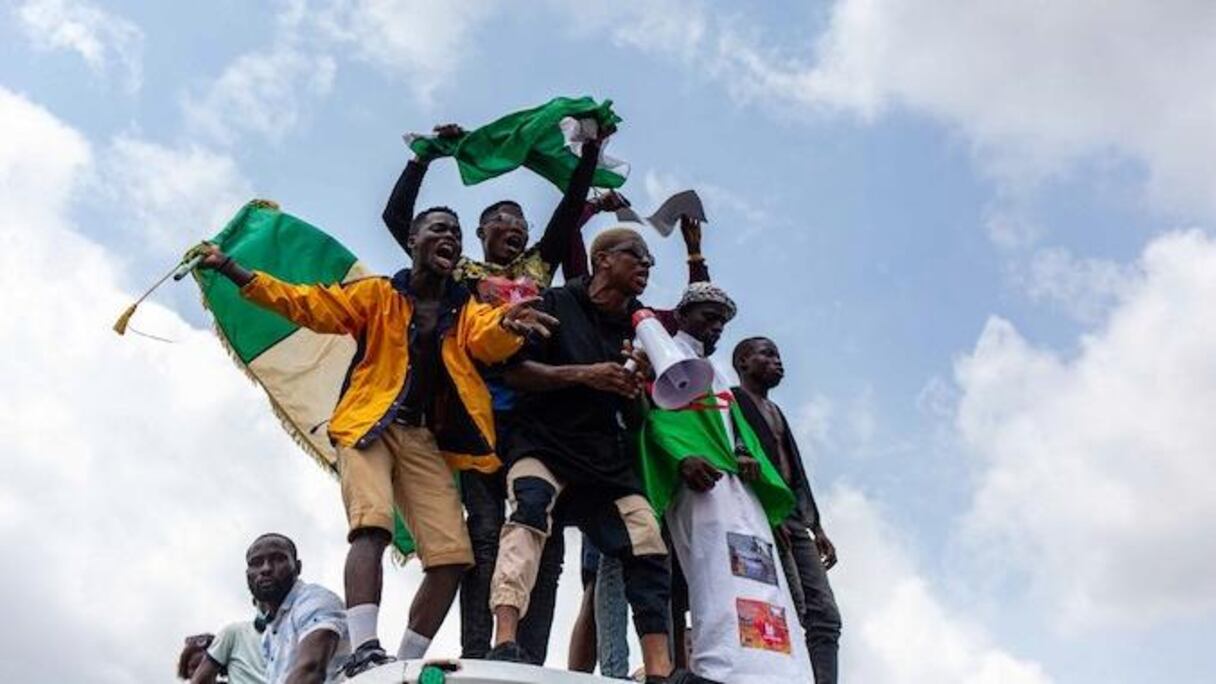 De jeunes Nigérians agitant le drapeau de leur pays, lors de protestations contre la police.