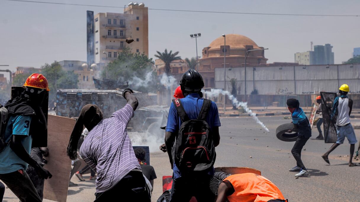 Des manifestants anti-coup d'État se cachent derrière des boucliers de fortune tandis que les forces de sécurité tirent des larmes lors d'affrontements au milieu de manifestations de masse contre le régime militaire dans le centre de la capitale soudanaise Khartoum le 30 juin 2022.