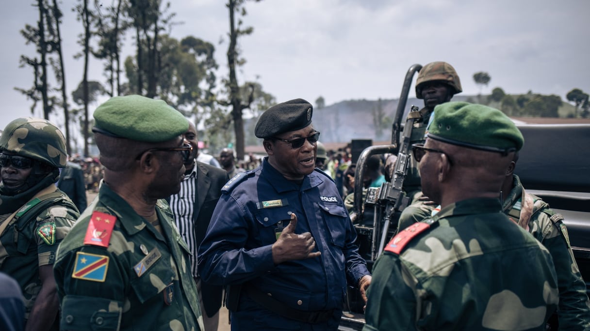 Des militaires et des policiers discutent à l'issue d'une réunion dans un camp informel de personnes déplacées qui ont fui l'avancée de la rébellion du M23 (Mouvement du 23 mars) à Kanyaruchinya, le district nord de Goma, le 2 novembre 2022.