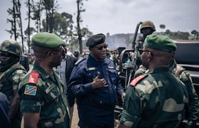 Des militaires et des policiers discutent à l'issue d'une réunion dans un camp informel de personnes déplacées qui ont fui l'avancée de la rébellion du M23 (Mouvement du 23 mars) à Kanyaruchinya, le district nord de Goma, le 2 novembre 2022.