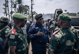 Des militaires et des policiers discutent à l'issue d'une réunion dans un camp informel de personnes déplacées qui ont fui l'avancée de la rébellion du M23 (Mouvement du 23 mars) à Kanyaruchinya, le district nord de Goma, le 2 novembre 2022.
