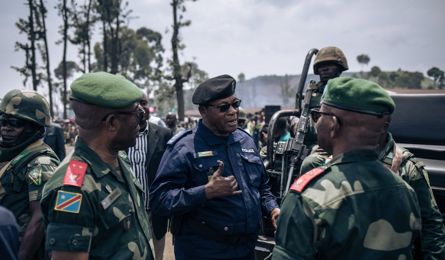Des militaires et des policiers discutent à l'issue d'une réunion dans un camp informel de personnes déplacées qui ont fui l'avancée de la rébellion du M23 (Mouvement du 23 mars) à Kanyaruchinya, le district nord de Goma, le 2 novembre 2022.