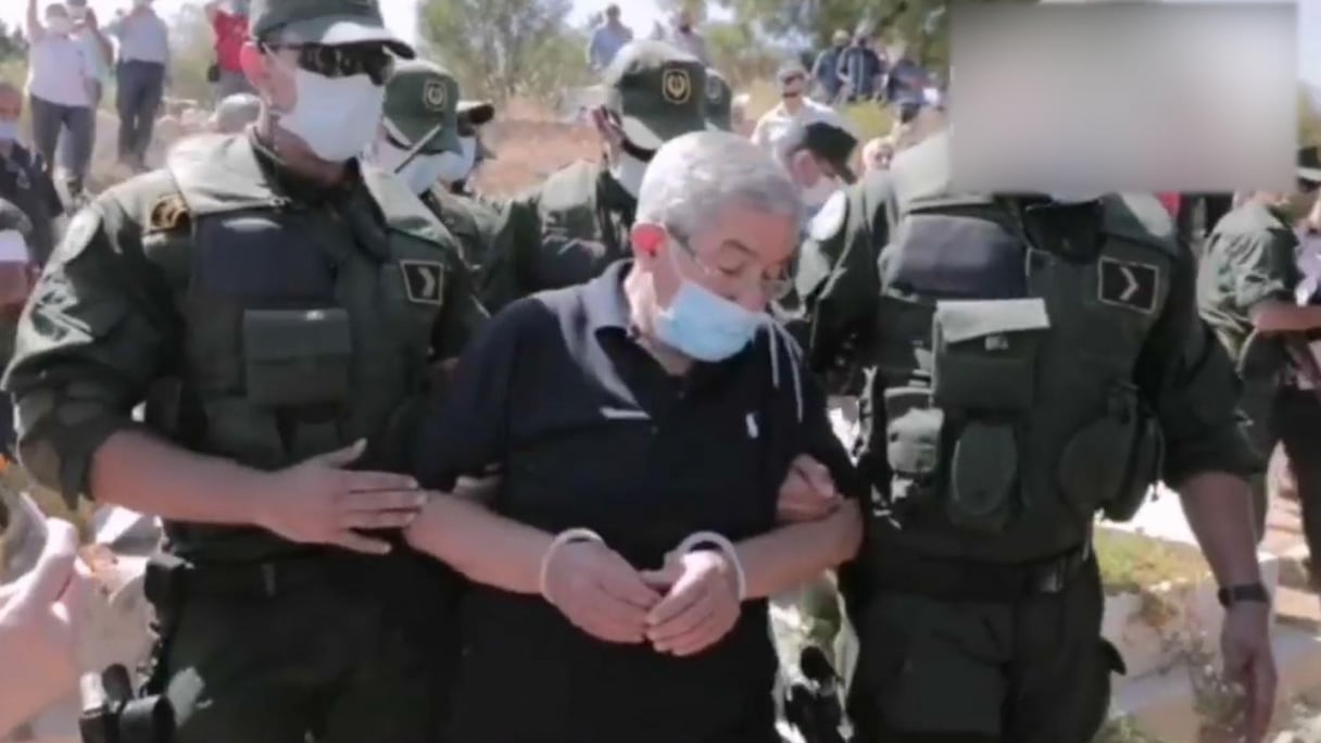 L'ancien Premier ministre algérien, Ahmed Ouyahia, assiste à l'enterrement de son frère, menottes aux poignets.