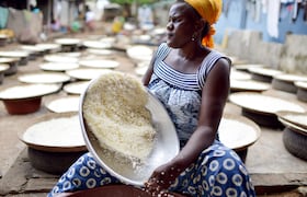 À Abidjan, une femme tamise de la farine de manioc pour la préparation de l'attiéké, un classique de la cuisine ivoirienne