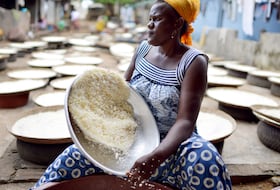 À Abidjan, une femme tamise de la farine de manioc pour la préparation de l'attiéké, un classique de la cuisine ivoirienne