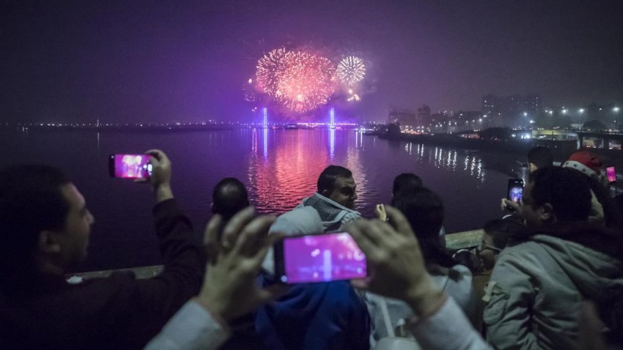 Des spectateurs scrutent les feux d'artifice exploser sur le Nil dans la capitale égyptienne Le Caire lors des célébrations du Nouvel An, dans la nuit du 31 décembre 2020 au 1er janvier 2021.
