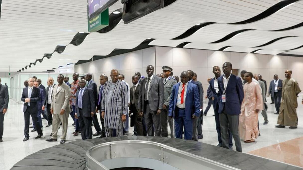 Alors que l'aéroport est loin d'être prêt, Macky Sall ne se prive pas de le faire visiter à ses hôtes. Ici, avec le président burkinabè Roch Marc Christian Kaboré dans la zone bagages.