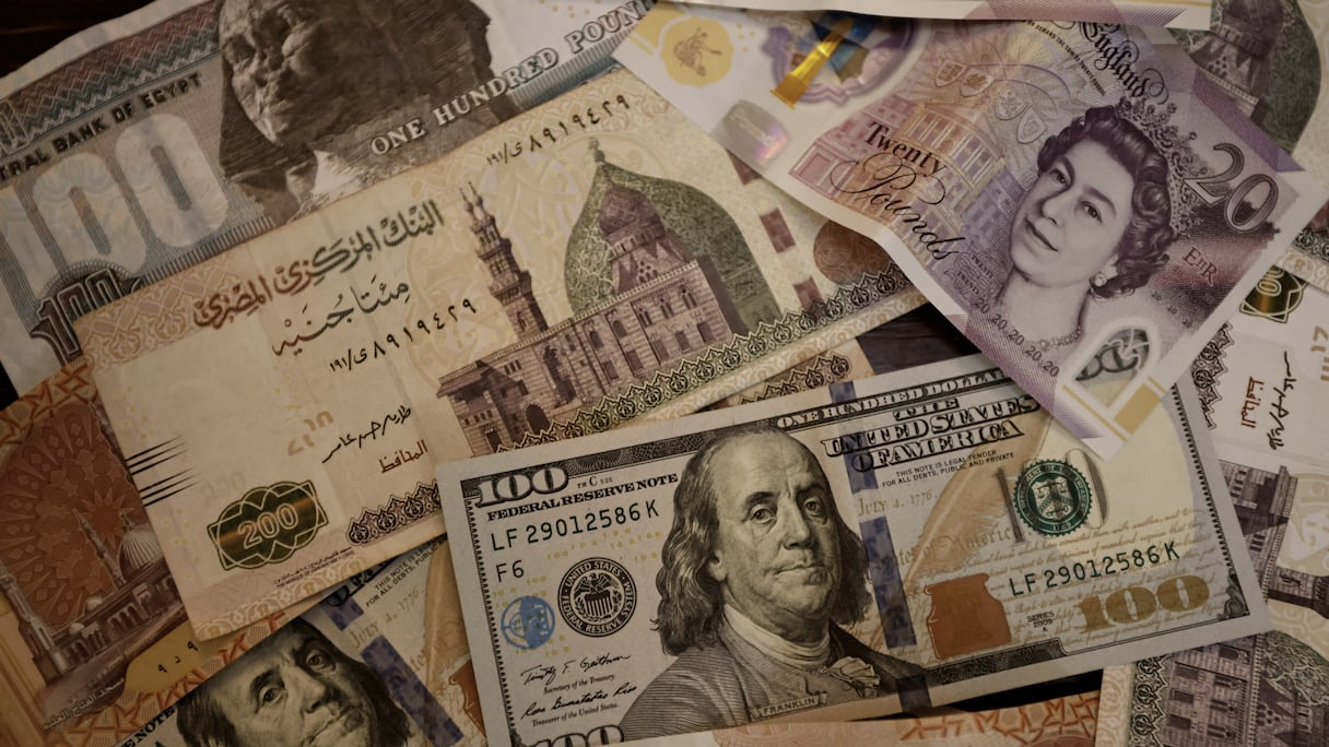 Une photo prise le 25 août 2022 montre des billets en livre égyptienne, en livre sterling et en dollars américains.