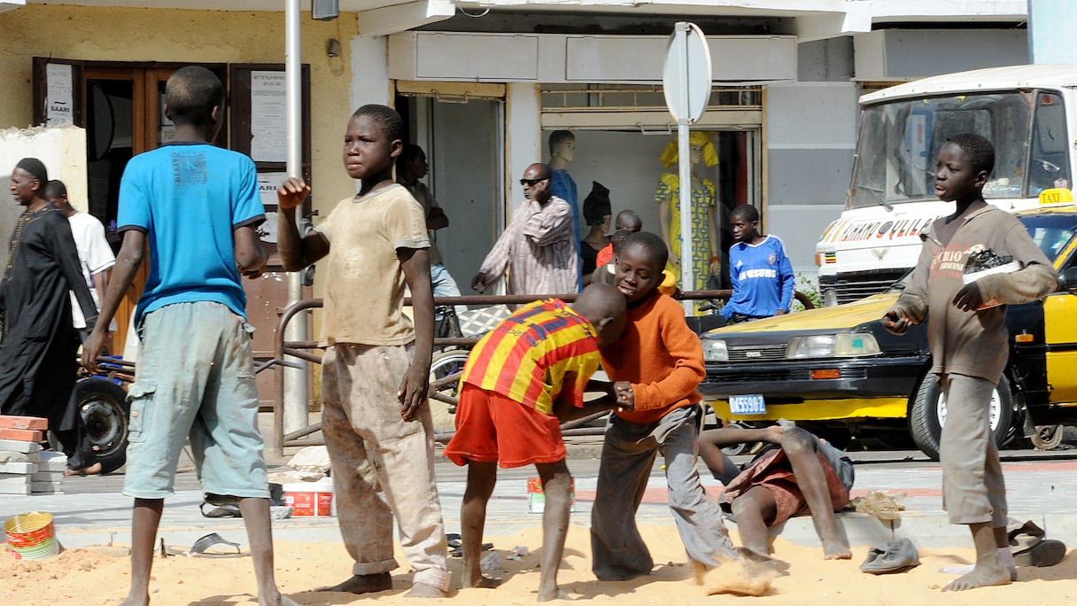 Des jeunes Talibs (élèves d'une école coranique) jouent le 20 mars 2014 sur l'avenue du Général Charles De Gaulle à Dakar. Le Sénégal ne parvient pas à protéger des milliers de garçons dans des internats islamiques contre la mendicité forcée et la torture aux mains de leurs enseignants.