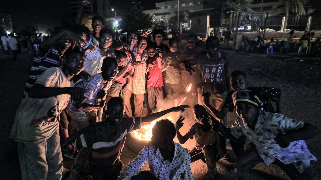 De jeunes manifestants soudanais réunis autour d'un feu de camp, ce 4 juillet 2022 au Royal Care Hospital à Barari dans la capitale Khartoum.
