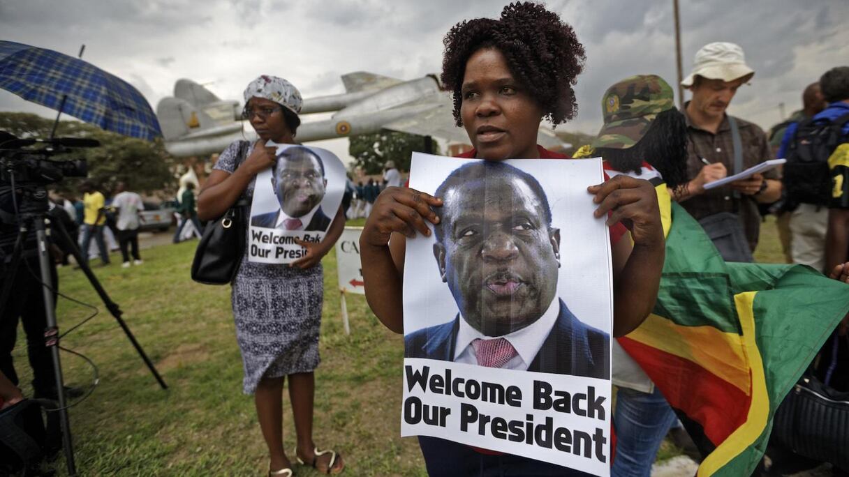 Des Zimbabwéennes brandissant le portrait de leur nouveau président, quand il revenait de son court exil.