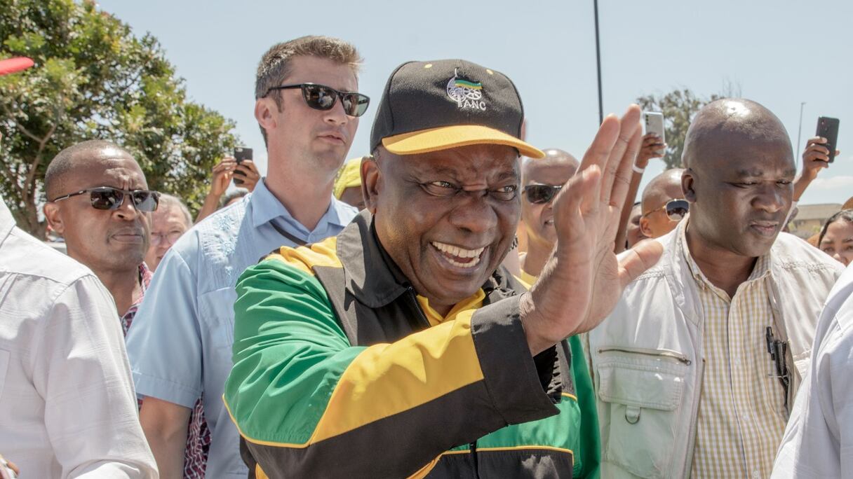 Le président sud-africain Cyril Ramaphosa salue la foule à son arrivée pour une rencontre avec les habitants du township de Philippi, au Cap, le 10 décembre 2022.