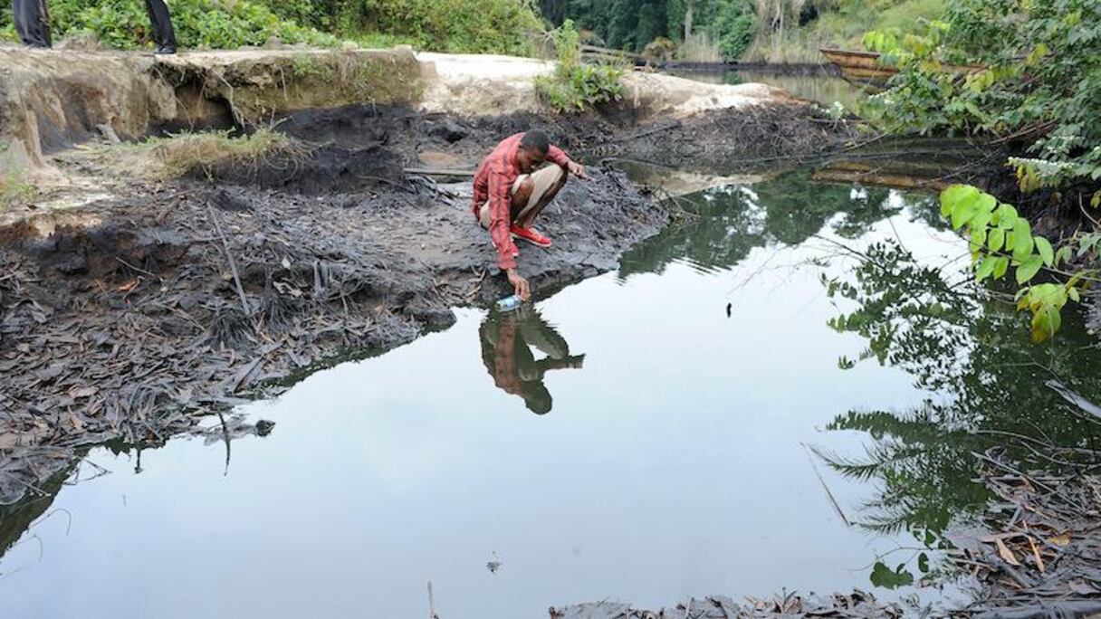 Mercredi 11 août, un homme écope du pétrole supposé provenir des installations de Shell dans l'Etat de Rivers State au Nigeria.