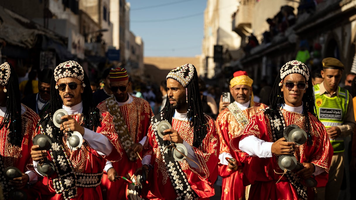 Une troupe traditionnelle gnaoua défile dans les rues lors de la cérémonie d'ouverture de la 25e édition du Festival Gnaoua et Musiques du Monde à Essaouira, au Maroc, le 27 juin 2024.