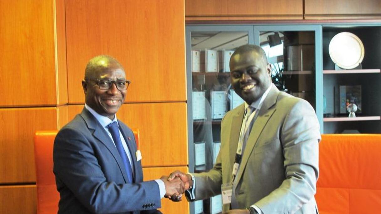 Khadim Bâ (à dr.), Directeur général de Locafrique échangeant des documents avec Jean-Louis Ekra (à g.), Président de Afreximbank, pour un crédit de 25 millions d'euros en faveur de Locafrique en décembre 2014.