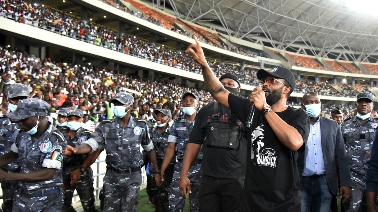 Le chanteur congolais Fally Ipupa (3e R), flanqué de policiers ivoiriens, se produit lors d'un concert en hommage à feu le Premier ministre ivoirien Hamed Bakayoko au stade olympique d'Ebimpe à Anyama, Abidjan, le 17 mars 2021. - Le Premier ministre ivoirien Hamed Bakayoko.