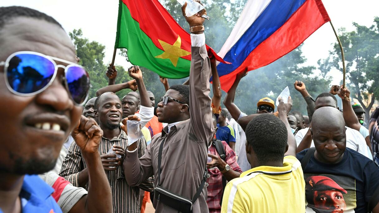 Les partisans du nouveau chef de la junte burkinabé Ibrahim Traoré tiennent les drapeaux nationaux du Burkina Faso et de la Russie lors d'une manifestation près du siège national de la radio et de la télévision (RTB) à Ouagadougou le 6 octobre 2022.