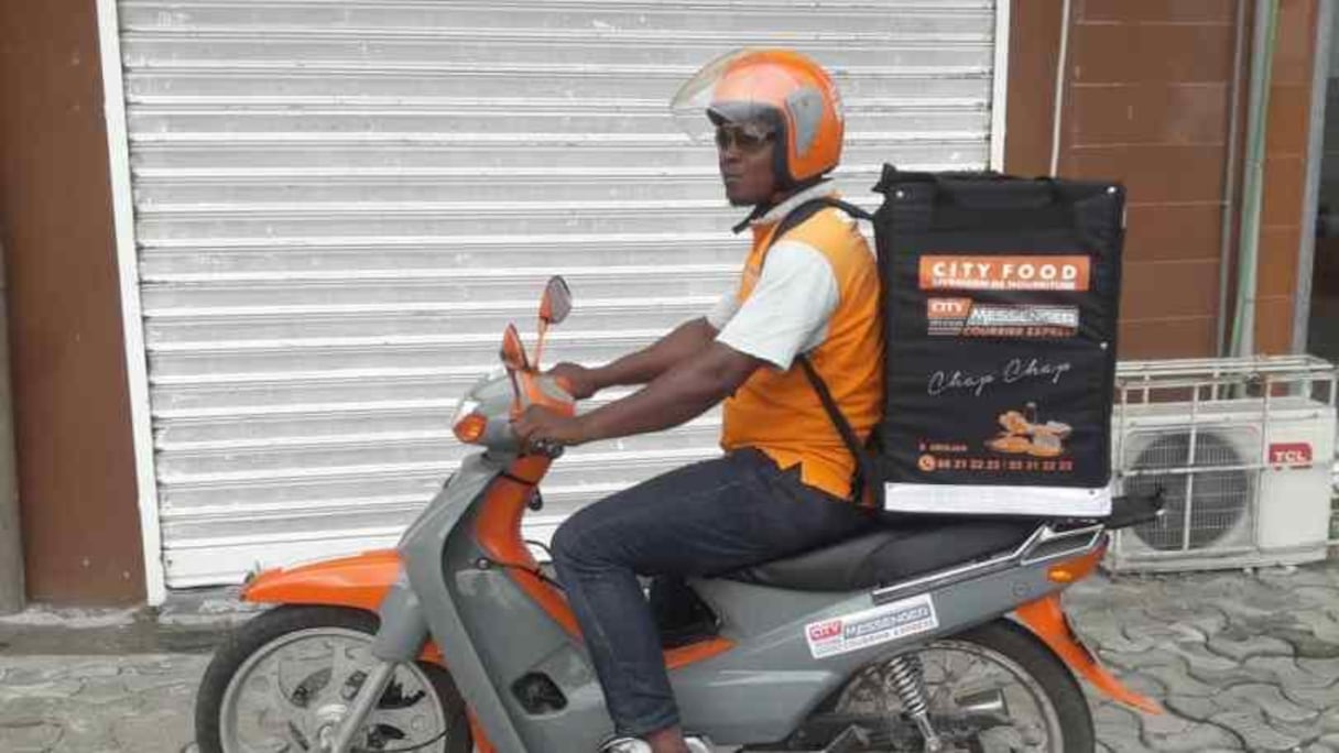 Un jeune livreur à moto