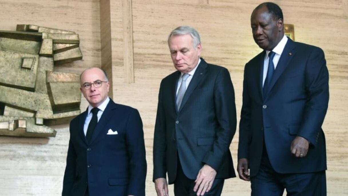 Le président ivoirien Alassane Ouattara (d) avec les ministres français des Affaires étrangères Jean-Marc Ayrault (c) et de l'Intérieur Bernard Cazeneuve (g) à Abidjan le 15 mars 2016 
© AFP SIA KAMBOU