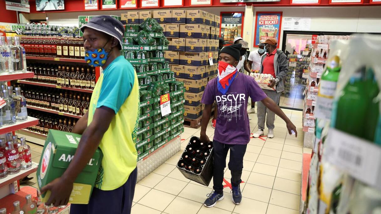 Des clients s'emparant de caissons d'alcool dans un supermarché en Afrique du Sud.