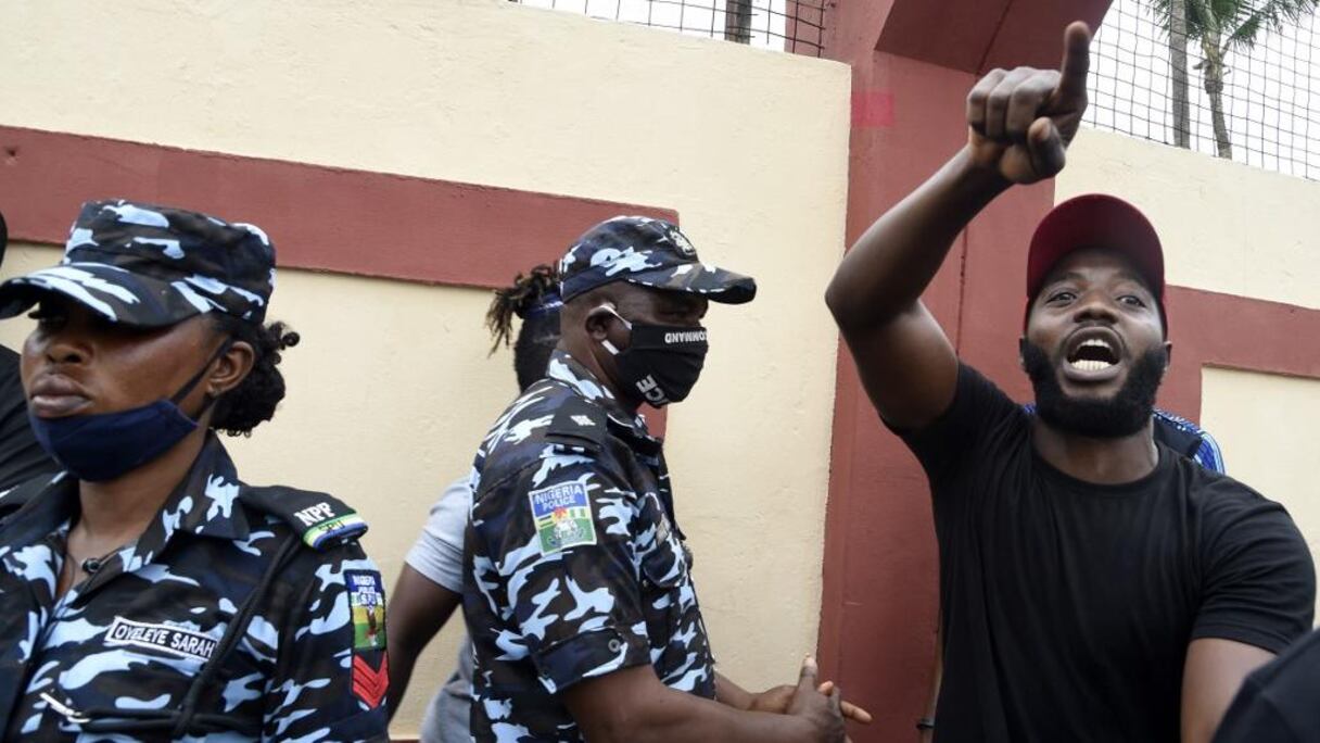 Un manifestant devant des forces de police nigérianes.