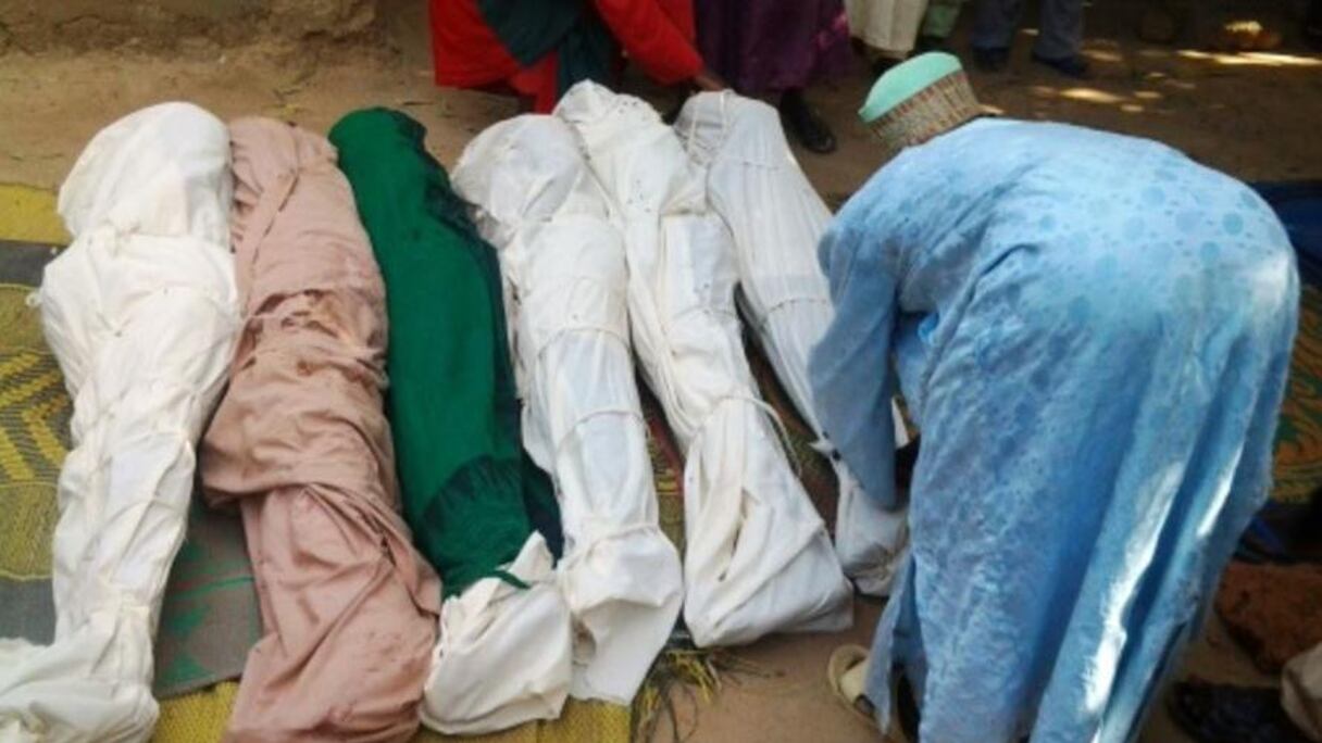 Un habitant enveloppe les corps des personnes abattues.